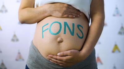 Op de buik van een zwangere vrouw staat het woord FONS geschilderd